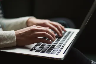 Hände schreiben auf Laptoptastatur