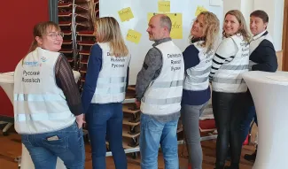  6 Personen mit Westen als Dolmetscher